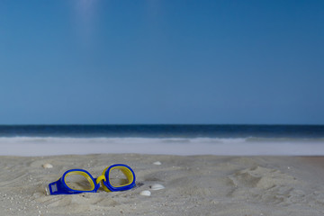 Swim goggles in the sand on the beach