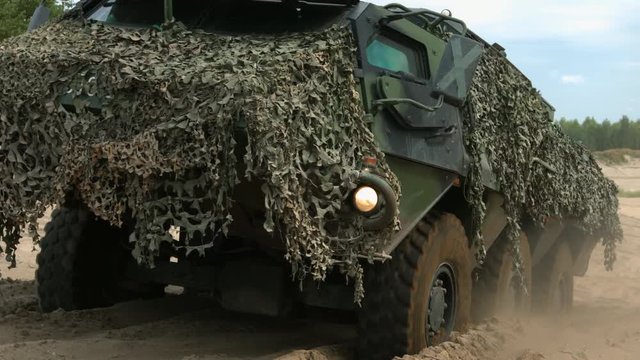 Armored military vehicle 8x8 wheeled BTR driving offroad in sand desert