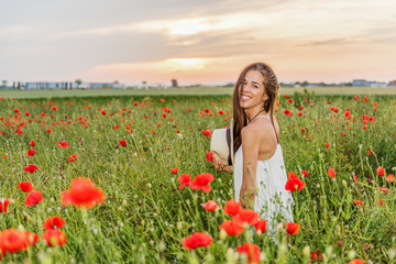 Naklejka na ściany i meble Happy woman in the field of red poppies