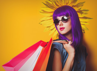 Collage of a young girl with purple hair and shopping bags and sunflower on yellow background
