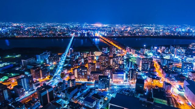 Japan Osaka City Skyline Timelapse. View from Umeda Sky Building. Overlooking the bridges with traffic and train going in and out of the Osaka city center. Zoom out shot. 