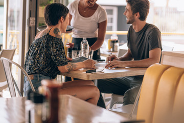 Couple at restaurant ordering food