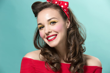 Fototapeta premium Beautiful young woman with pinup make-up and hairstyle. Studio shot on white background