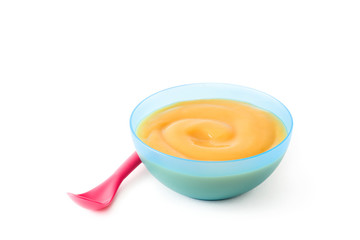 Baby food: blue bowl with fruit puree isolated on white background