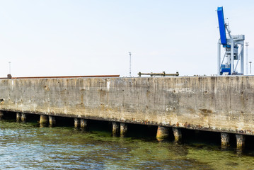 Obraz premium Harbor crane on an industrial concrete pier. Logo removed.