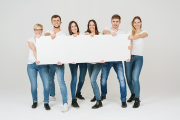 Happy group of people holding a panorama banner
