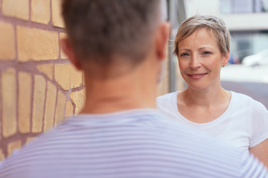 Attractive smiling woman chatting to a male friend