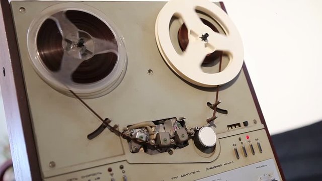Play and rewind the tape in the old reel tape recorder, Old reel-to-reel tape deck, the tape is twisted in coils on record player