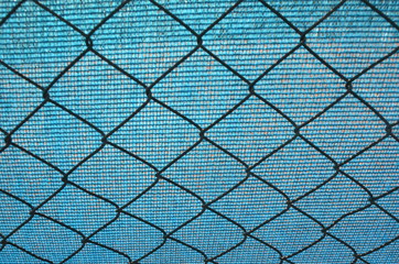 Naklejka premium Chain link fence and blue tarpaulin