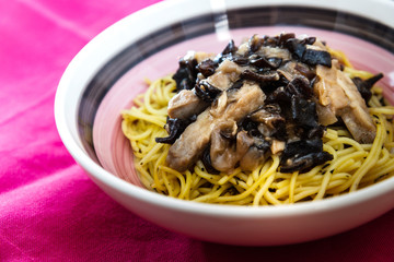 close-up of plate of pasta and chicken with lettuce