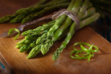 Green asparagus on wooden plate