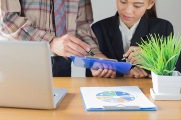 Business  colleagues discussing financial and graph analysis data on office table.