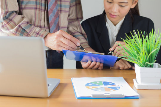 Business  colleagues discussing financial and graph analysis data on office table.