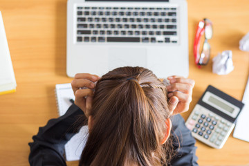 Businesswoman stressed and headaches while working on a computer.
