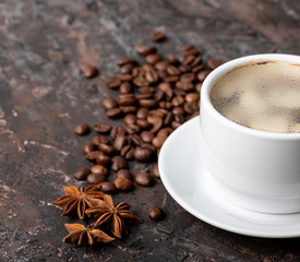 Coffee beans and cinnamon on a background of burlap. Roasted coffee beans background close up. Coffee beans pile from top with copy space for text. Seasoning. Spice. Cinnamon. Badian. Coffee house.