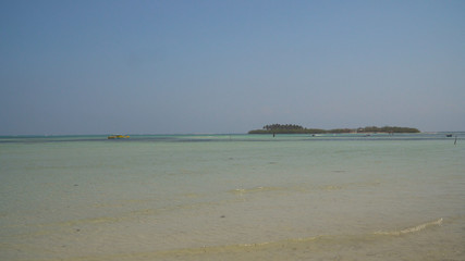 Tropical island with white sandy beach, palm trees in blue lagoon. Tanduyong island with turquoise water. Seascape, ocean and beautiful beach. Philippines, Anda, Pangasinan. Travel concept.