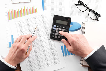 Businessman working with using a calculator to calculate the numbers. Finance accounting concept