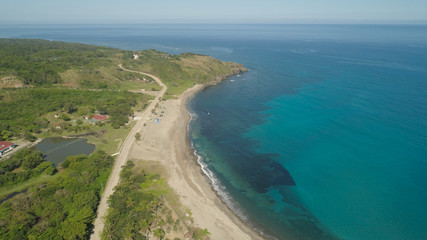 Fototapeta na wymiar Aerial view of beautiful beach, lagoon and coral reefs. Philippines, Pagudpud. Ocean coastline with turquoise water. Tropical landscape in Asia.