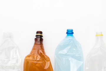 Different types of crushed plastic bottles on white background. Copyspace for text. Recyclable waste. Recycling, reuse, garbage disposal, resources, environment and ecology concept.
