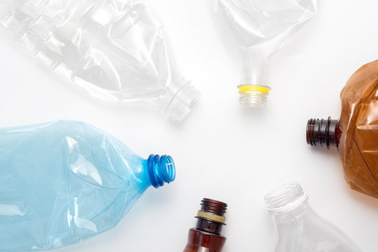 Different types of crushed plastic bottles on white background. Copyspace for text. Recyclable waste. Recycling, reuse, garbage disposal, resources, environment and ecology concept.