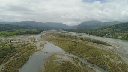 Mountain valley with river, farmland in the Philippines, Luzon. Aerial view of mountains covered forest, tree. Cordillera region.