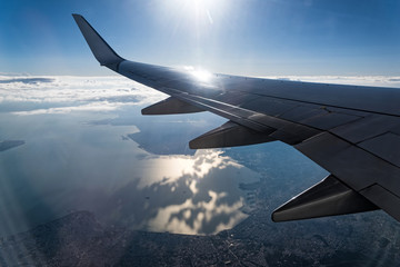 Fototapeta premium View through the window of the wing of an airplane flying above the clouds