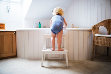 Toddler boy in a dangerous situation in the bathroom.