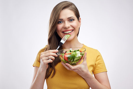 Smiling healthy girl eating green salad.
