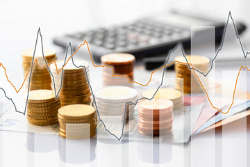 Euro coins in pile on Euro banknotes with charts, background. Germany