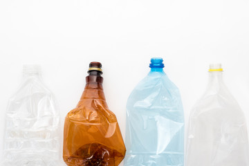 Different types of crushed plastic bottles on white background. Copyspace for text. Recyclable waste. Recycling, reuse, garbage disposal, resources, environment and ecology concept.