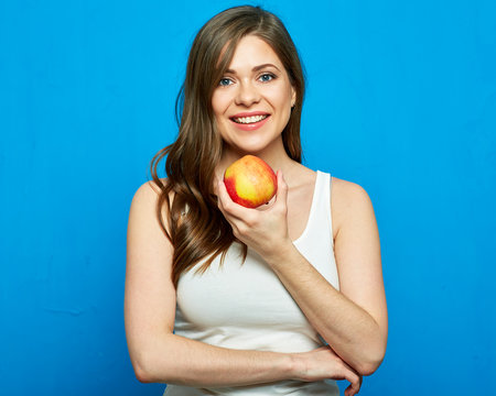 Smiling girl holding red apple.