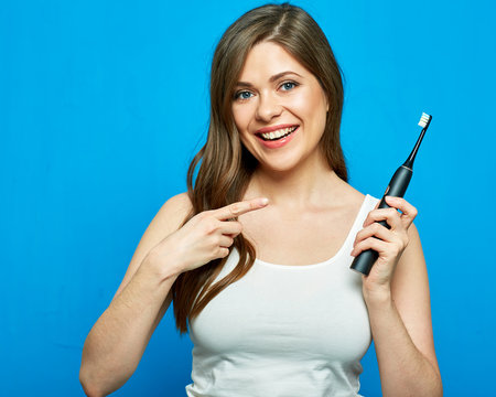 Woman pointing finger on electric toothbrush.