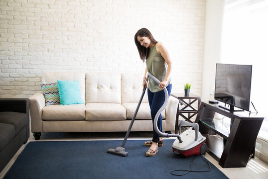 Happy woman cleaning house living room