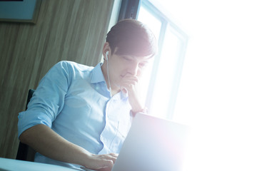 Businessman using a phone and a laptop.