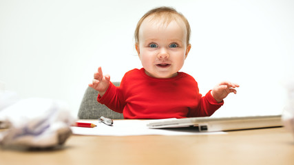 Happy child baby girl toddler sitting with keyboard of computer isolated on a white background