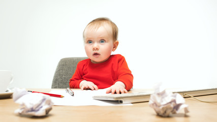 Happy child baby girl toddler sitting with keyboard of computer isolated on a white background