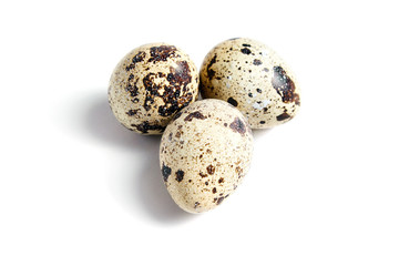 Three Quail spotted eggs, isolated on a white background