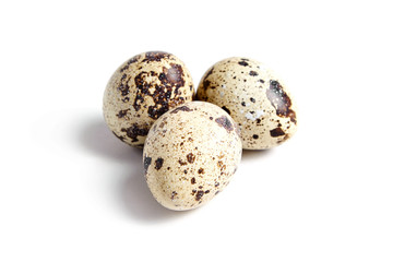 Obraz premium Three Quail spotted eggs, isolated on a white background