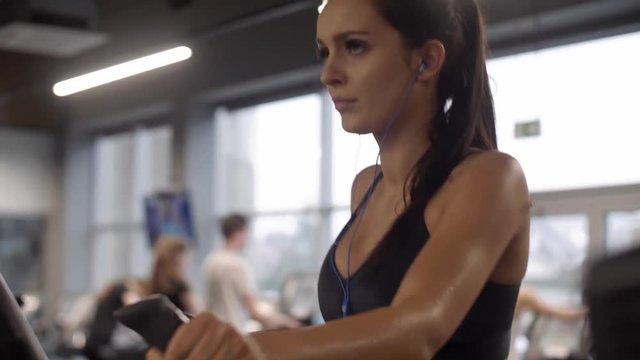 Woman with headphones exercising at gym