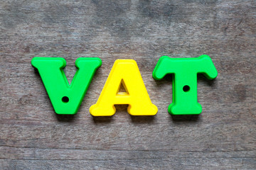 Color alphabet in word VAT (value added tax) on wood background