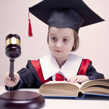 One law for all concept. Humorous photo of child girl judge (lawyer).
