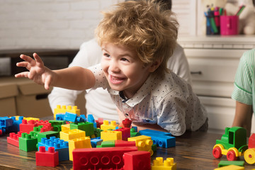 Child play with toy construction bricks. Family games concept.