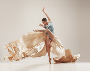 Modern ballet dancer dancing in full body on white studio background.