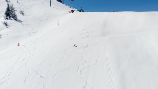 Aerial: one person skiing on snow in Sestriere ski resort, Turin Italy, sunny day, sport adventure in the italian Alps