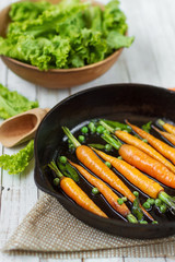 fried young carrots in a frying pan