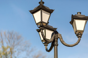 Street metal lamp on the sky background, town lights