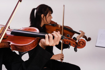 In selective focus of the lady hand press on string of violin,the duet of violin song,blurry light...
