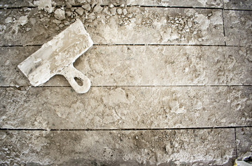 dirty spatula on a construction table stained in plaster lime putty