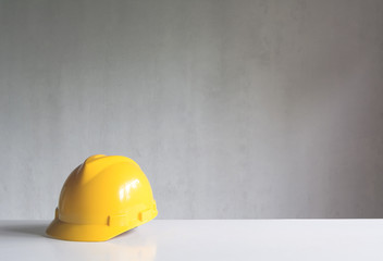 Construction tools or safety equipment with yellow helmet on table.
