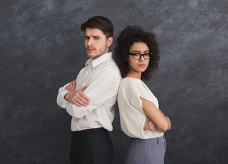 Confident business couple on gray background